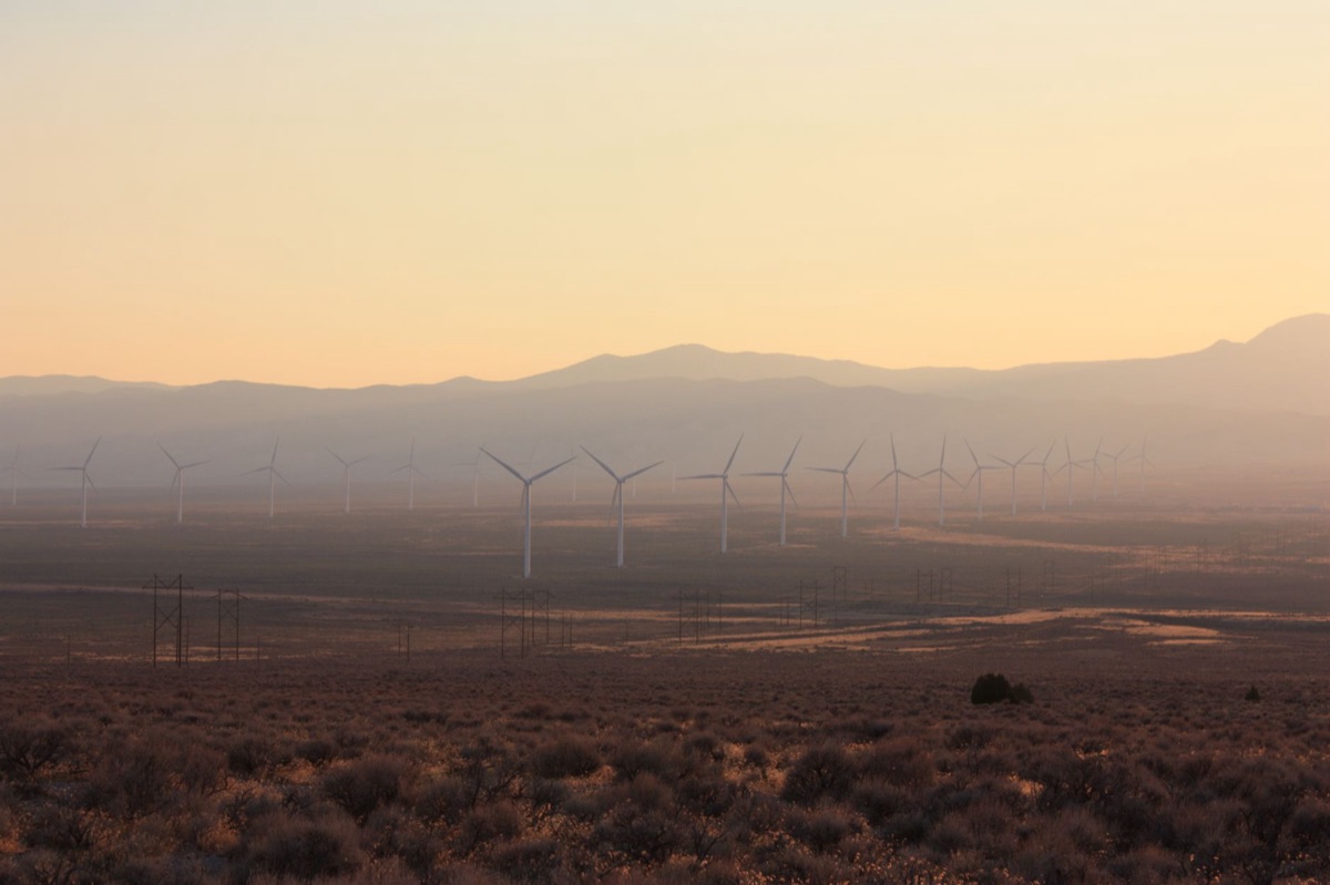 Row of vertical-axis wind turbines in a mountainous landscape
