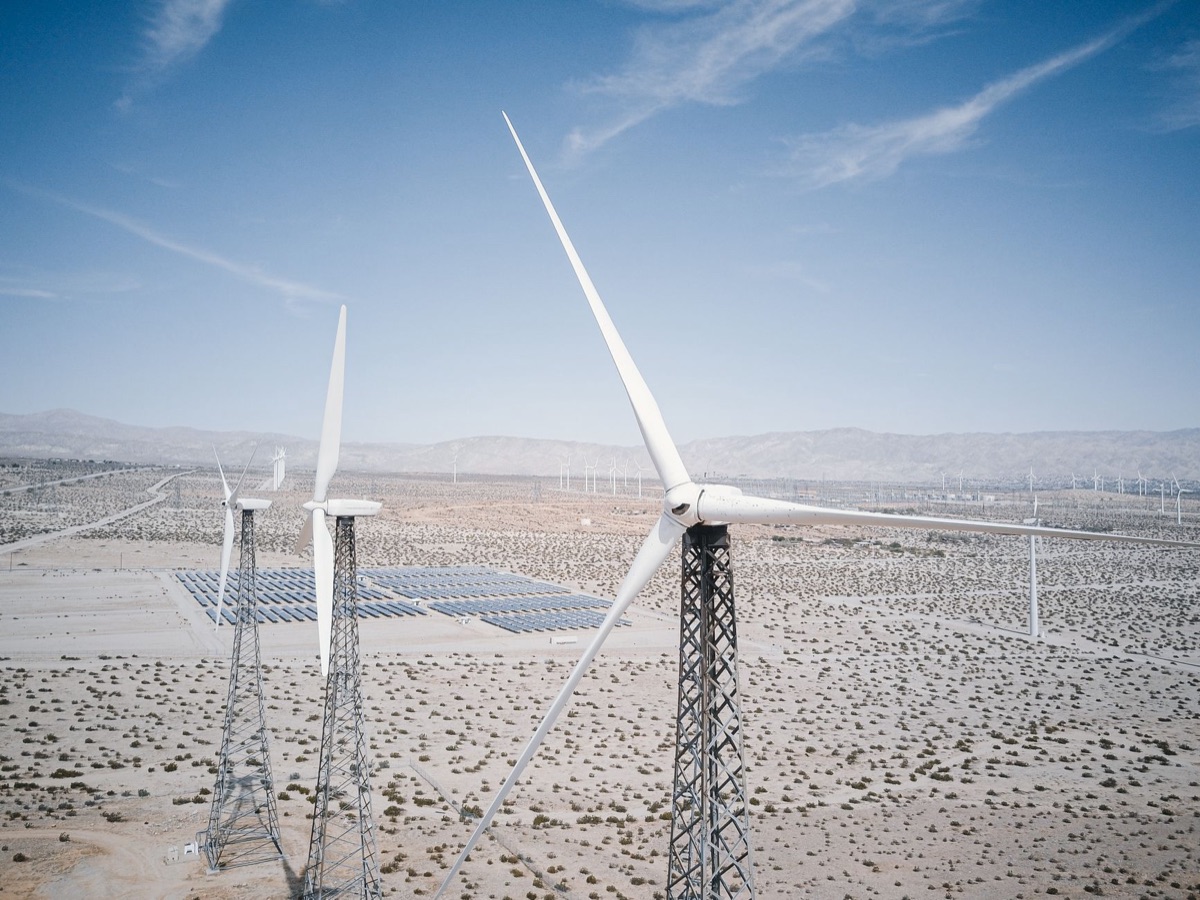 Renewable energy farm with solar panels and wind turbines integrated with ESS