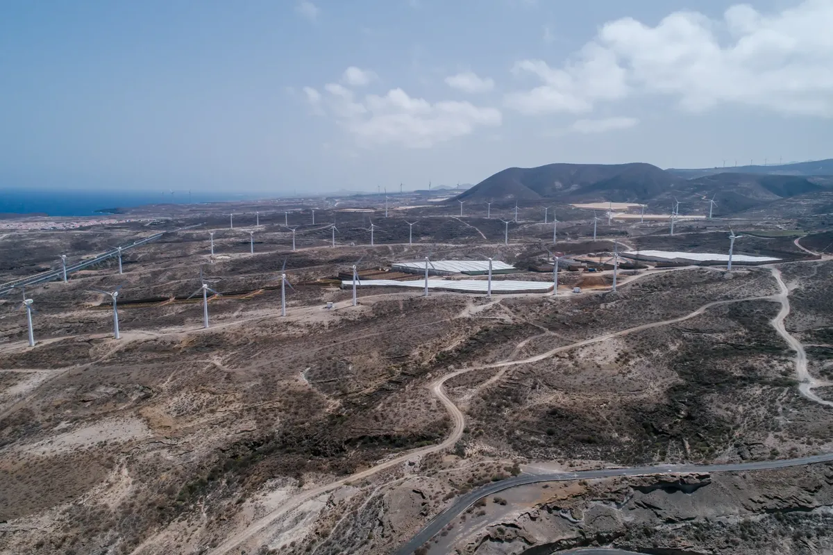 A stunning aerial view of a vast wind farm in a dry and arid landscape, showcasing renewable energy.