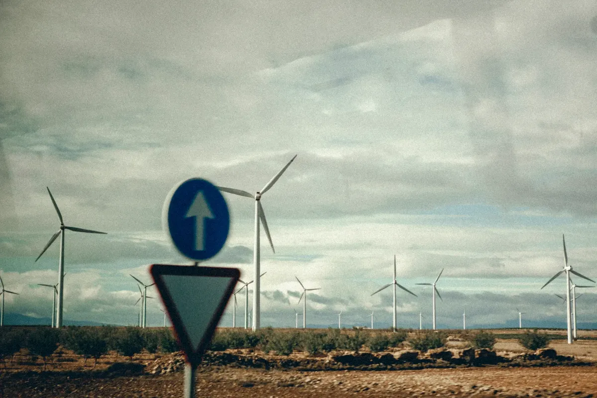 鄉間風力發電機與路牌的風景，強調可再生能源