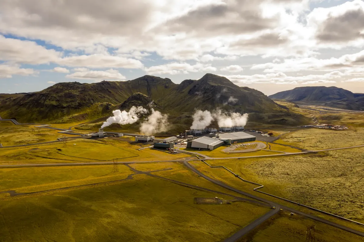 Aerial view of Hellisheidi geothermal power plant with mountains and steam in Iceland