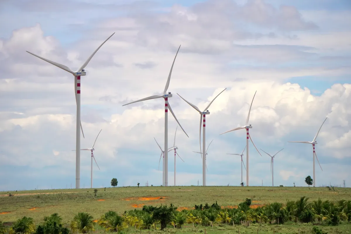 A scenic landscape featuring multiple wind turbines against a cloudy sky, symbolizing renewable energy.